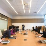 Colleagues around a conference table looking at a woman who is speaking during a team training session