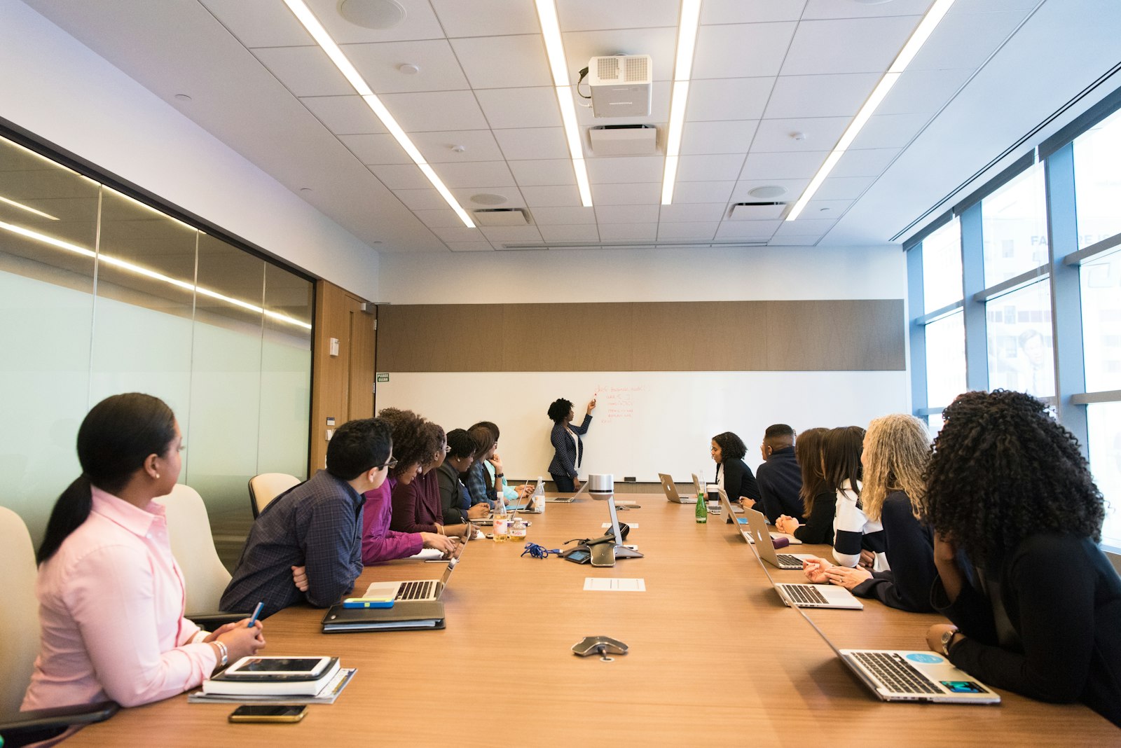 Colleagues around a conference table looking at a woman who is speaking during a team training session