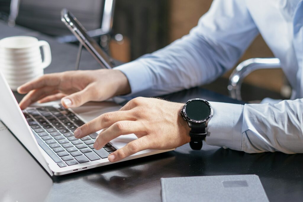 Person typing on a laptop at a desk, completing an online training course